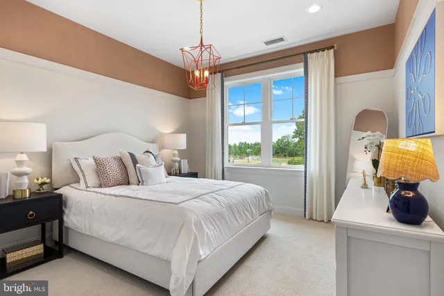 a bedroom with a large bed and a chandelier