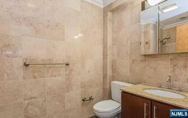 a bathroom with a granite countertop sink a toilet and shower