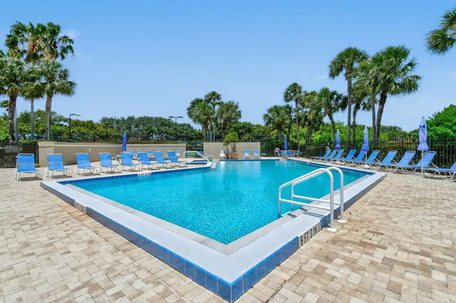 view of a swimming pool with a lounge chairs