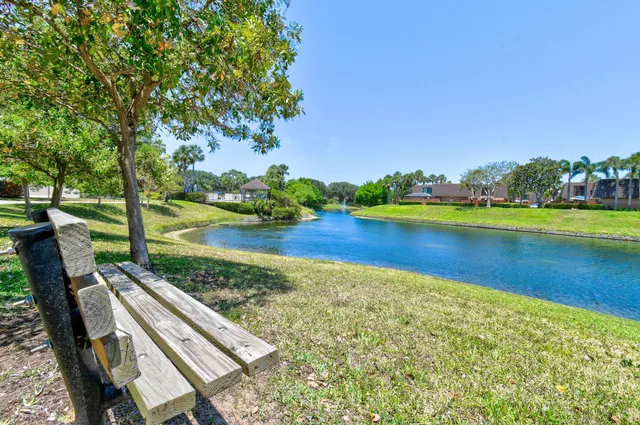 a view of a lake with lawn chairs