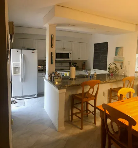 a kitchen with stainless steel appliances granite countertop a refrigerator and a stove top oven