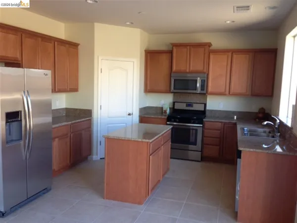 a kitchen with stainless steel appliances granite countertop a refrigerator stove and microwave