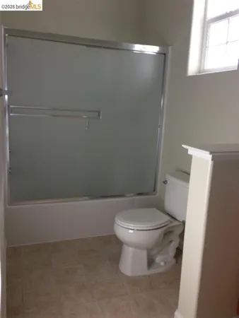 a white toilet sitting next to a bath tub