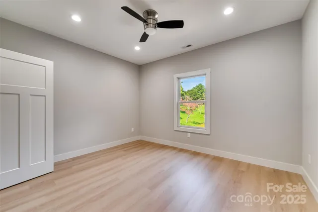 an empty room with window and wooden floor