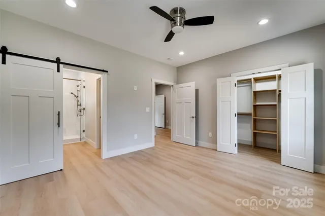 a view of empty room with wooden floor and ceiling fan