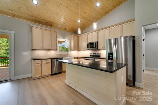 a kitchen with kitchen island granite countertop a stove sink and refrigerator