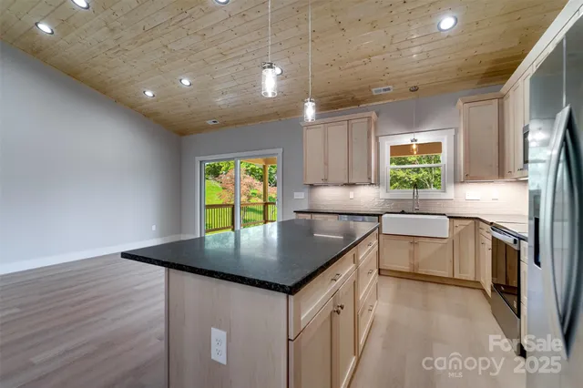 a kitchen with granite countertop a sink a counter top space and stainless steel appliances