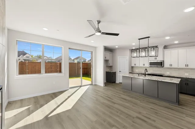 a large kitchen with stainless steel appliances granite countertop a large counter top and a sink