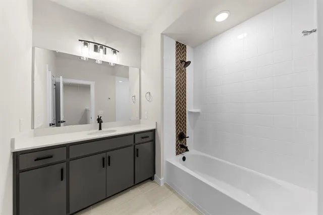 a bathroom with a tub a sink and mirror