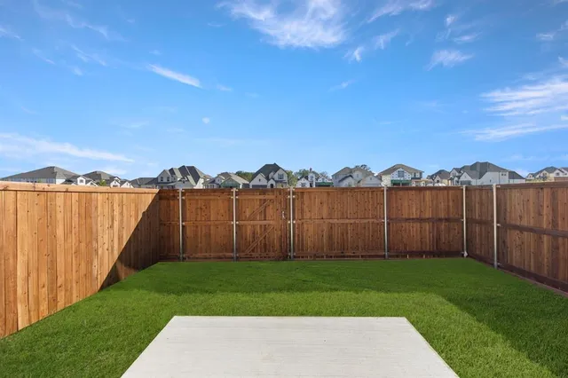 a view of a yard with wooden fence