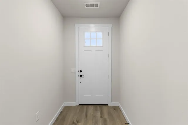 a view of a small space with wooden floor and a window