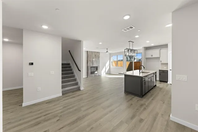 a view of a living room kitchen with furniture and wooden floor