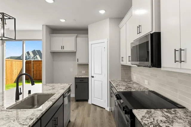 a kitchen with stainless steel appliances granite countertop a sink stove and refrigerator