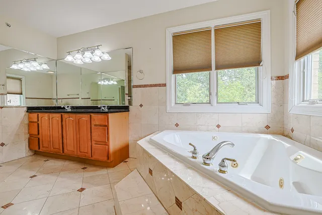 a bathroom with a tub sink and mirror