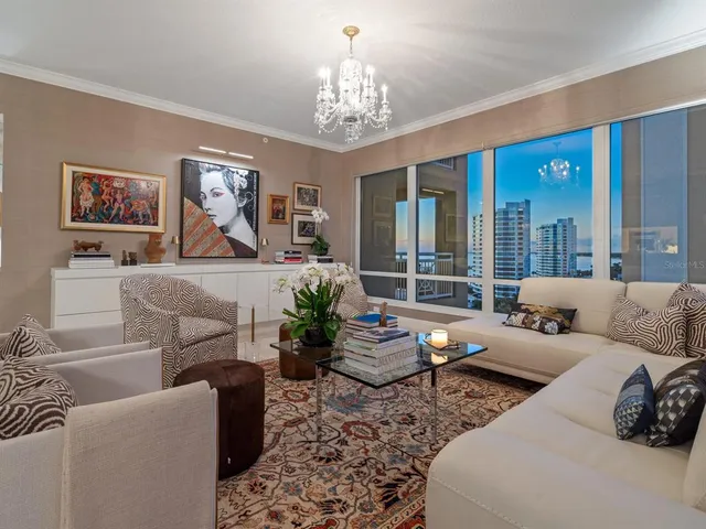 a living room with furniture and a chandelier