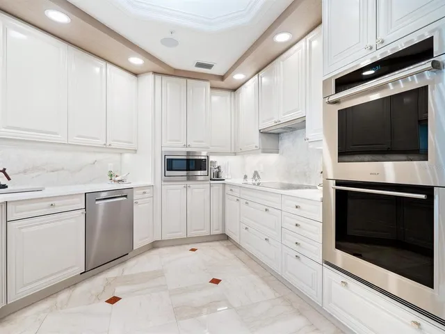 a view with granite countertop a sink and cabinets