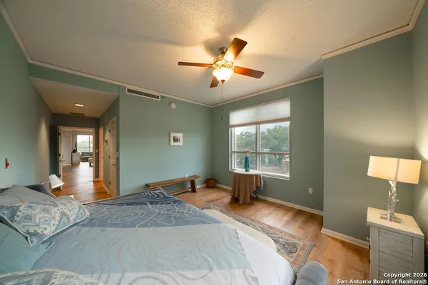 a spacious bedroom with a large bed and ceiling fan