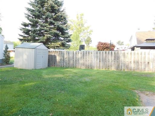 406 Fulton Street Middlesex, NJ 08846 - Photo 14 of 19 a view of a yard with a large tree and wooden fence
