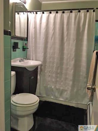 406 Fulton Street Middlesex, NJ 08846 - Photo 7 of 19 a bathroom with a toilet a sink and curtain