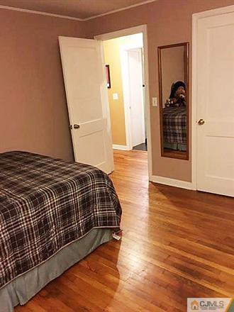 406 Fulton Street Middlesex, NJ 08846 - Photo 10 of 19 a bedroom with a bed and wooden floor