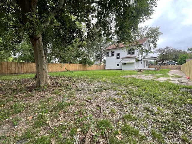 a white house that has a tree in front of it