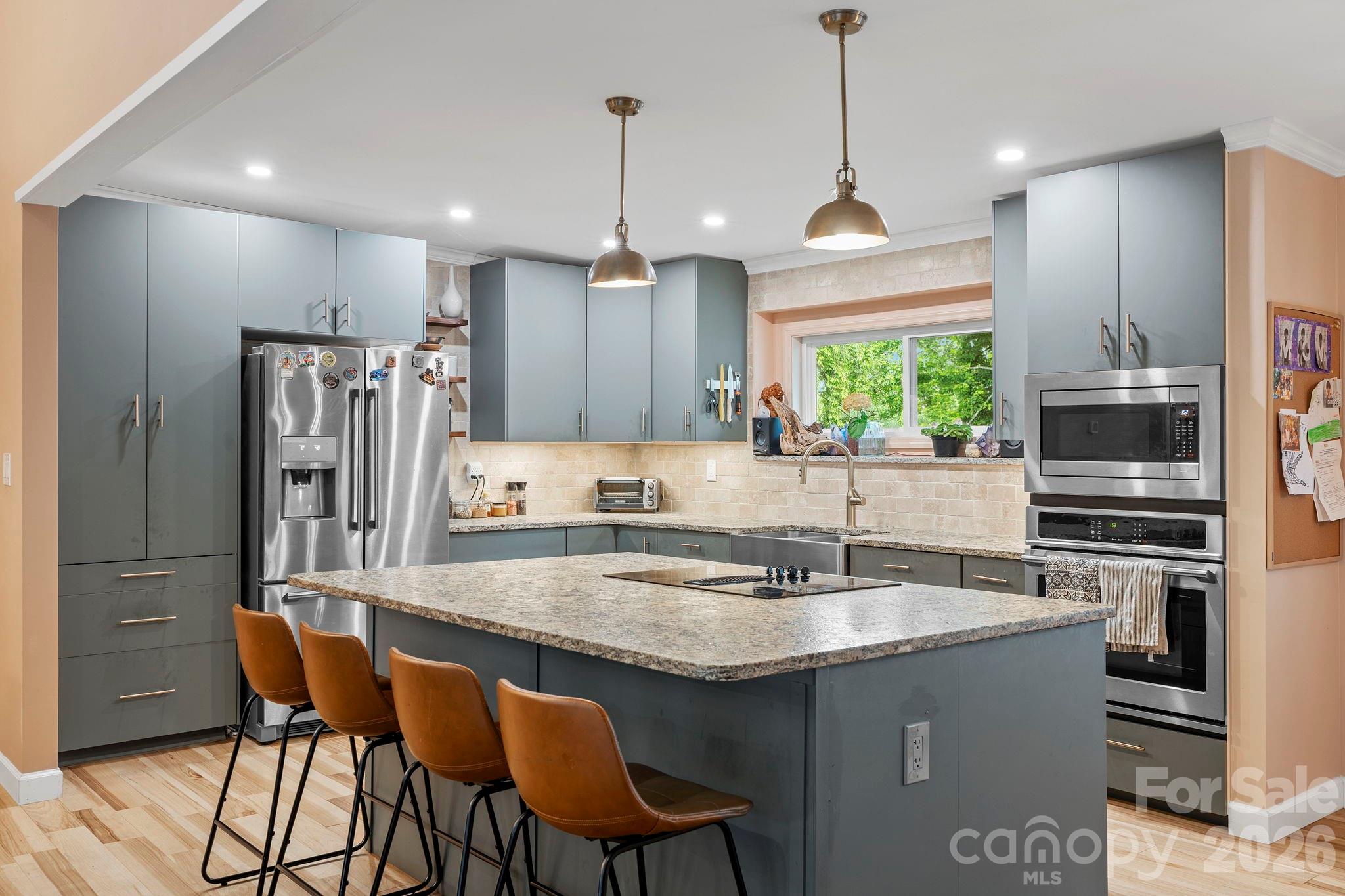 419 East Blue Ridge Road East Flat Rock, NC 28726 - Photo 12 of 44 a kitchen with stainless steel appliances granite countertop a sink a stove a refrigerator cabinets and chairs