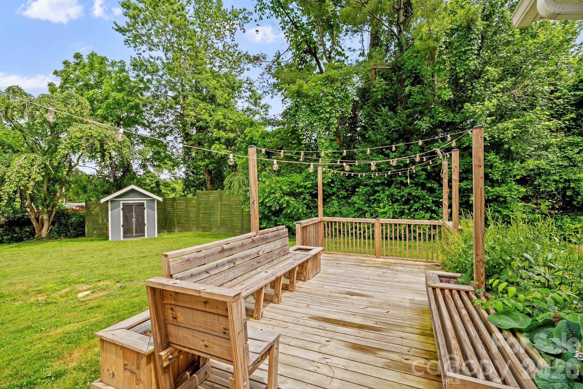 419 East Blue Ridge Road East Flat Rock, NC 28726 - Photo 38 of 44 a view of a patio with table and chairs with wooden floor and fence