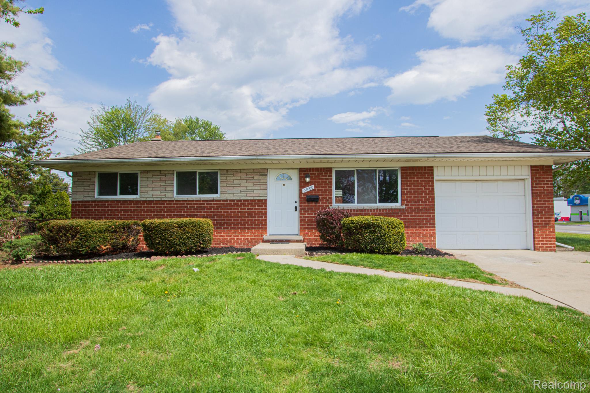 31000 Fall Fraser, MI 48026 - Photo 1 of 28 Ranch-style house featuring a front lawn, concrete driveway, an attached garage, a chimney, and brick siding
