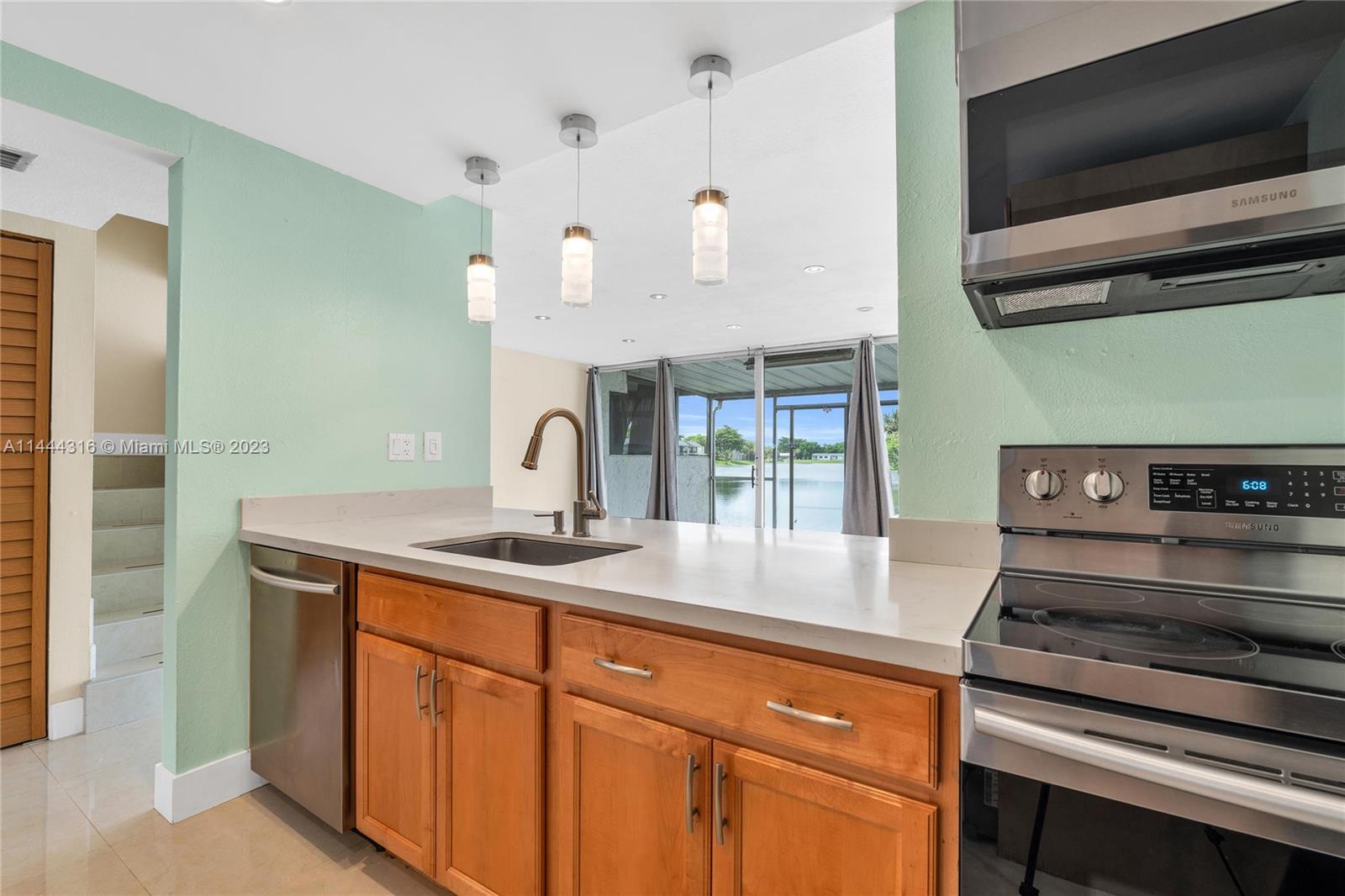 14001 Southwest 84th Street, Unit 1308 Miami, FL 33183 - Photo 17 of 47 a kitchen with a sink and a stove top oven with wooden floor