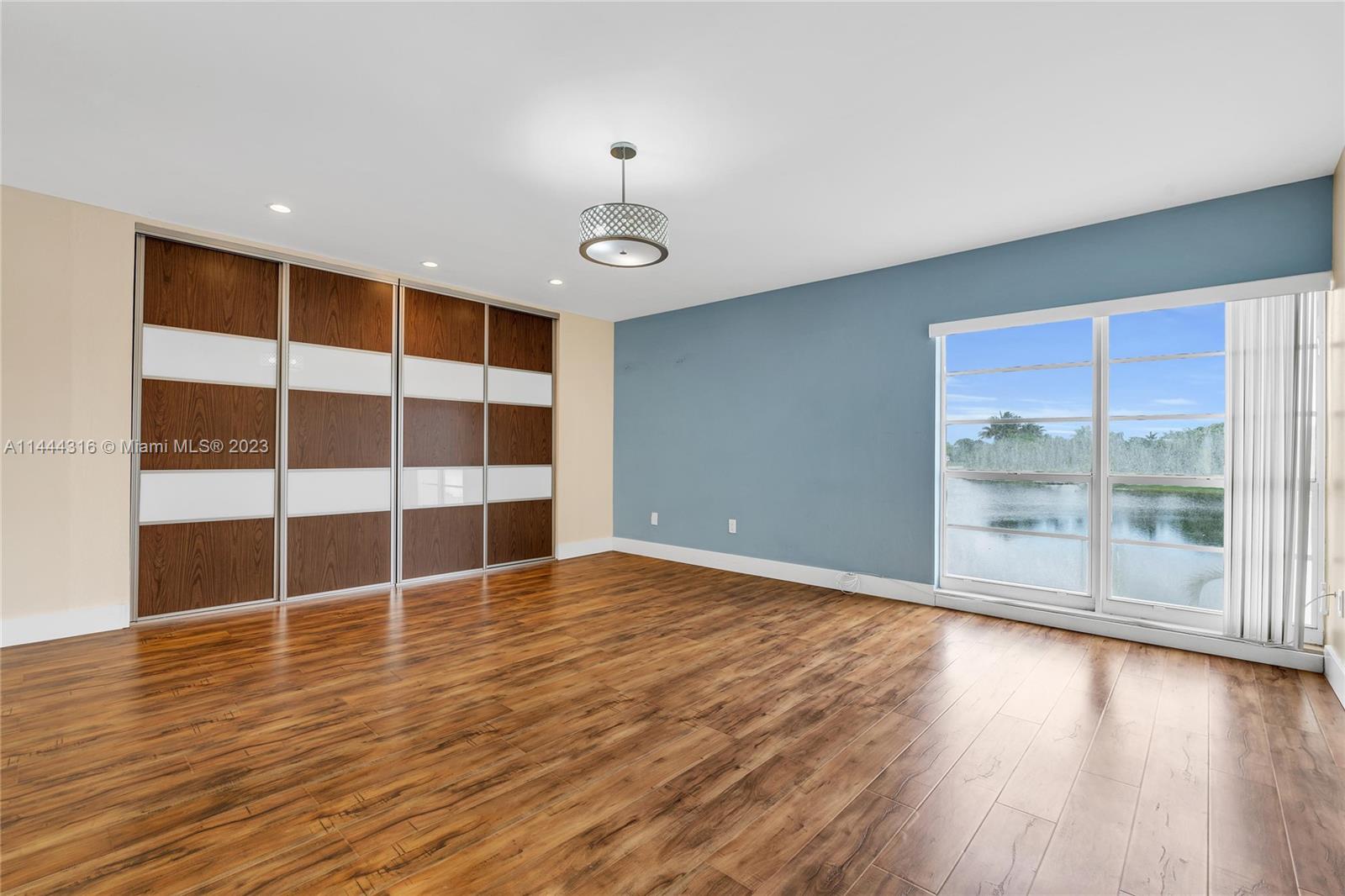 14001 Southwest 84th Street, Unit 1308 Miami, FL 33183 - Photo 22 of 47 a view of an empty room with wooden floor and windows