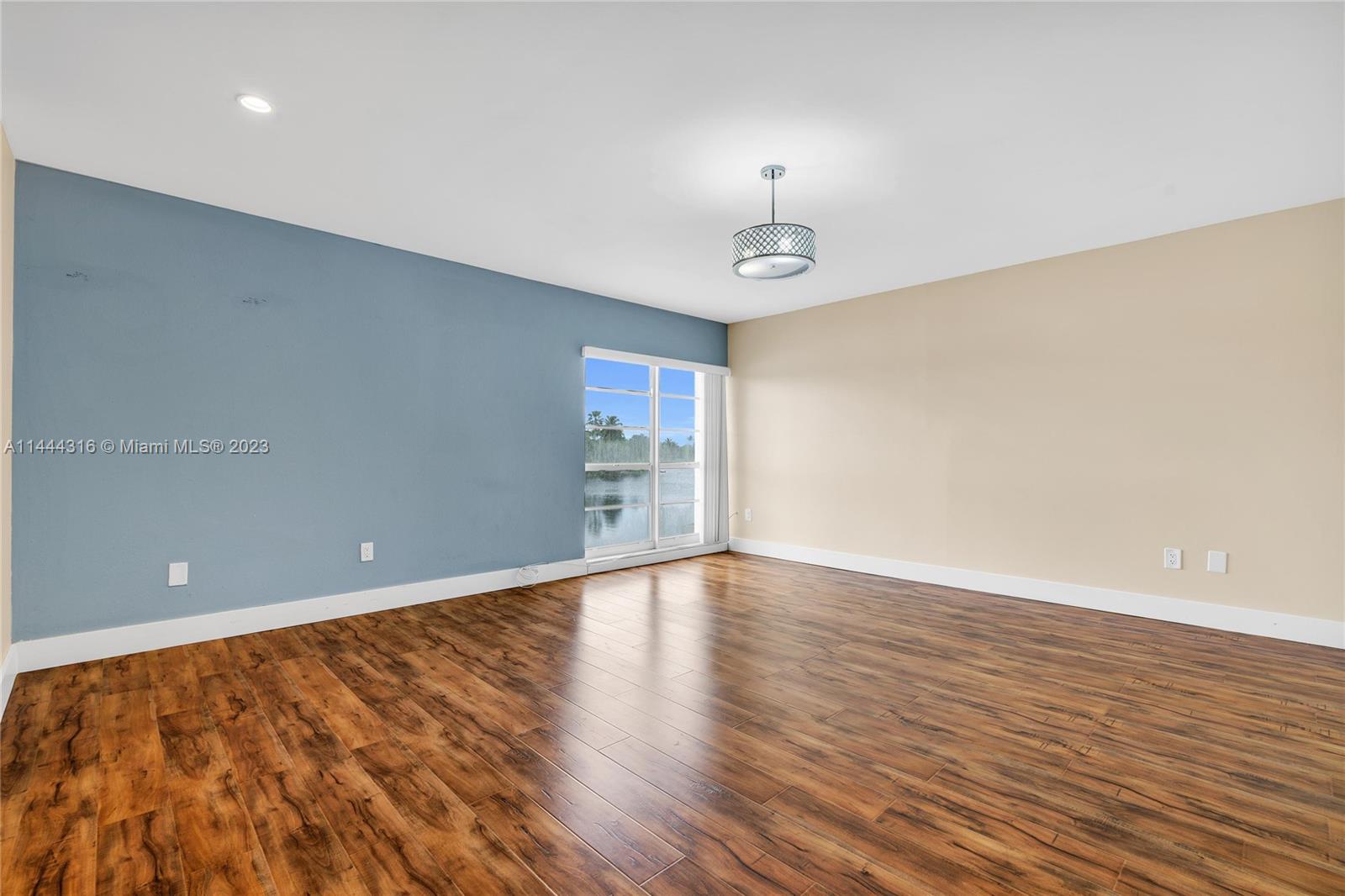 14001 Southwest 84th Street, Unit 1308 Miami, FL 33183 - Photo 24 of 47 a view of an empty room with wooden floor and a window