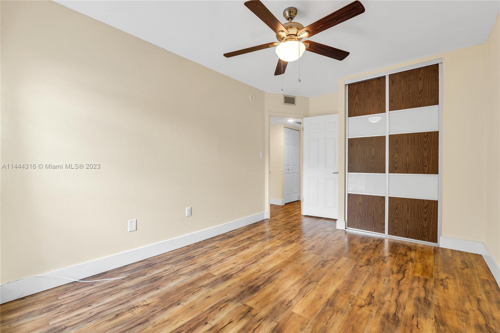 14001 Southwest 84th Street, Unit 1308 Miami, FL 33183 - Photo 26 of 47 an empty room with wooden floor and windows