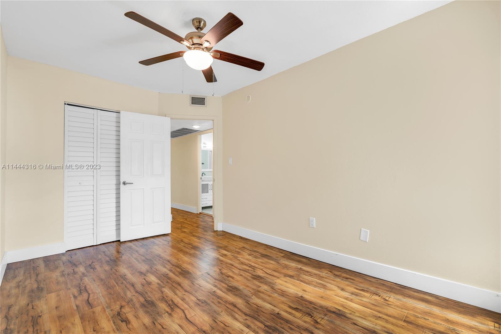 14001 Southwest 84th Street, Unit 1308 Miami, FL 33183 - Photo 28 of 47 an empty room with wooden floor ceiling fan and window
