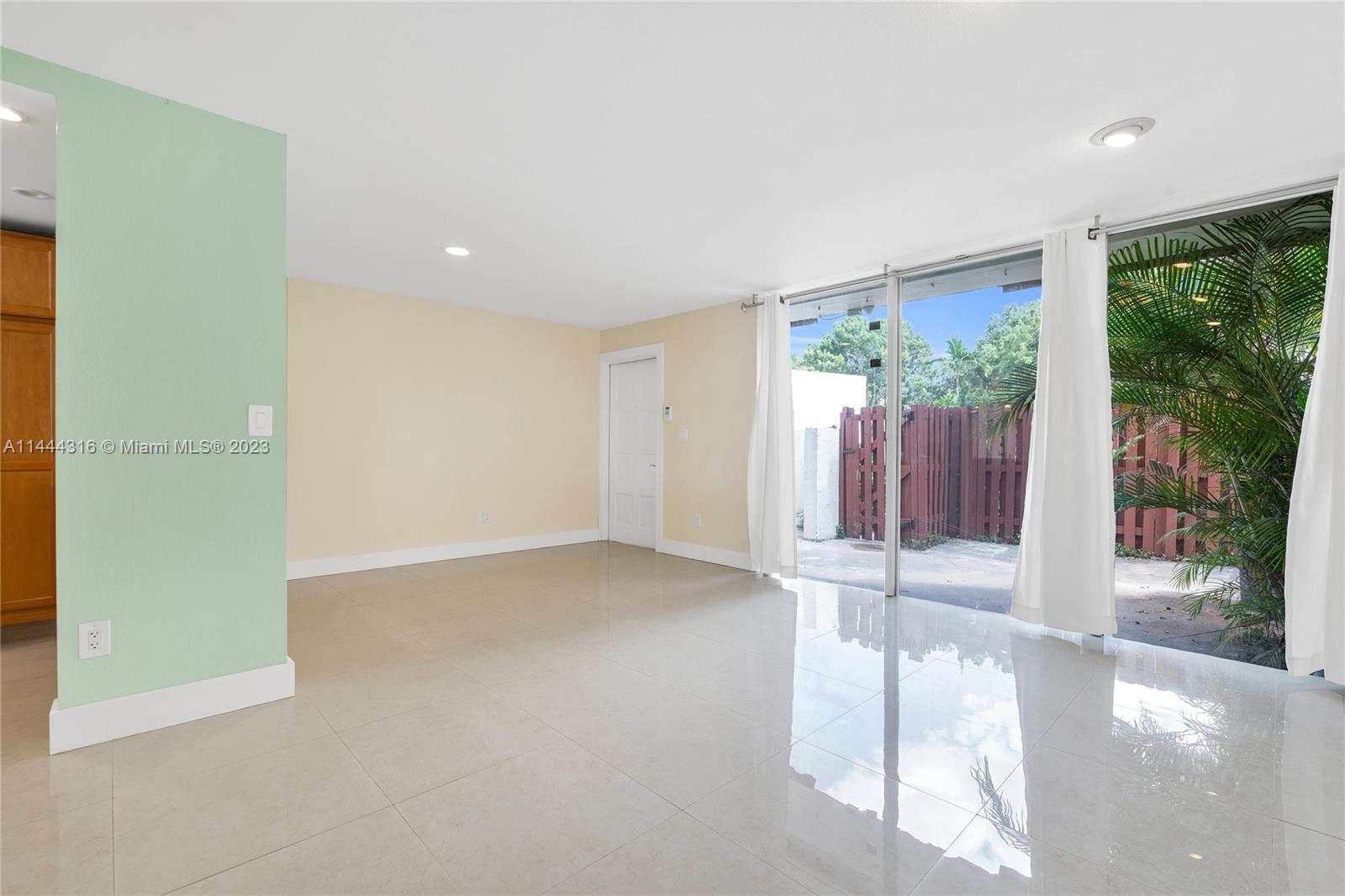 14001 Southwest 84th Street, Unit 1308 Miami, FL 33183 - Photo 9 of 47 a view of an empty room with wooden floor and a window