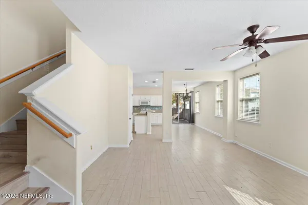 a view of empty room with wooden floor and windows