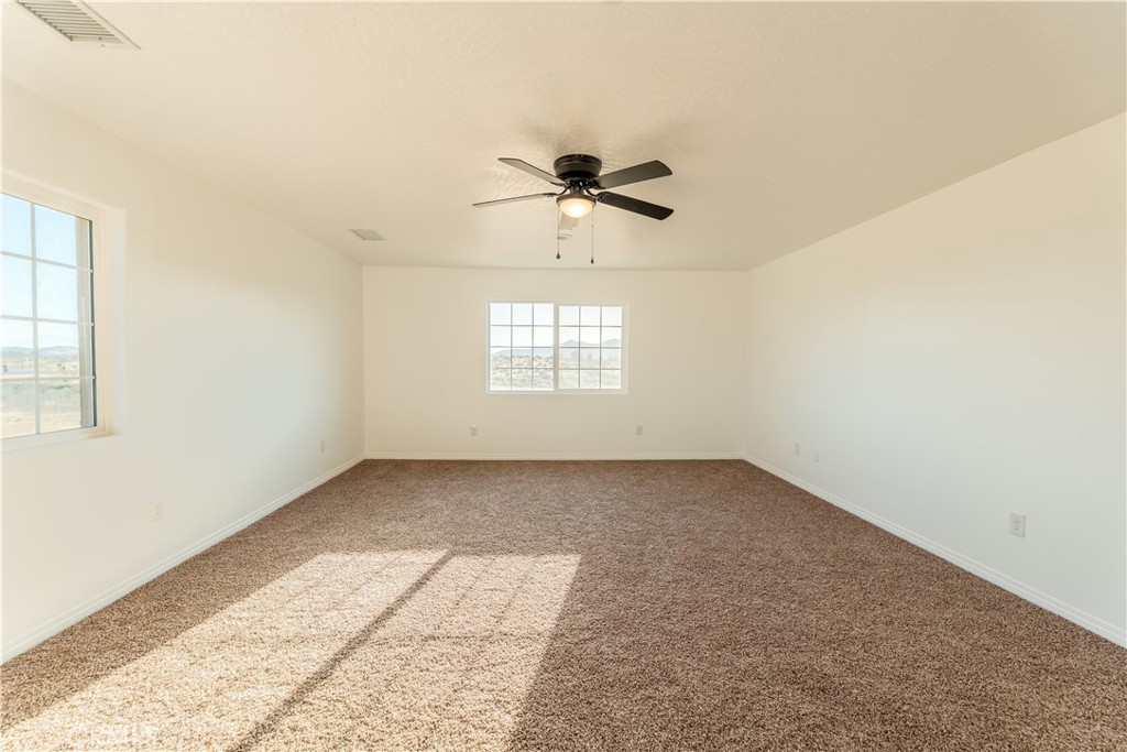 16925 Nanticoke Road Apple Valley, CA 92307 - Photo 51 of 87 an empty room with a window and a ceiling fan