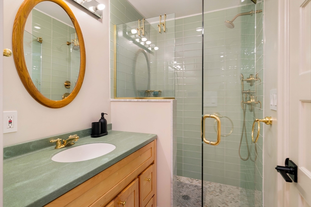 8 Naples Road, Unit 1 Brookline, MA 02446 - Photo 23 of 38 a bathroom with a sink mirror and vanity