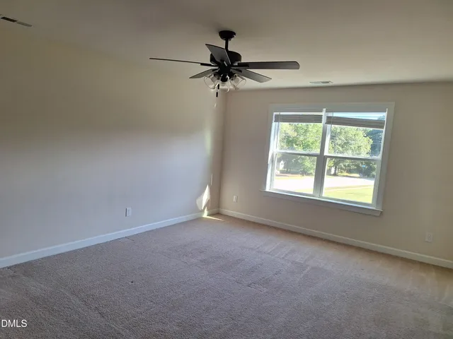 an empty room with a window and a ceiling fan
