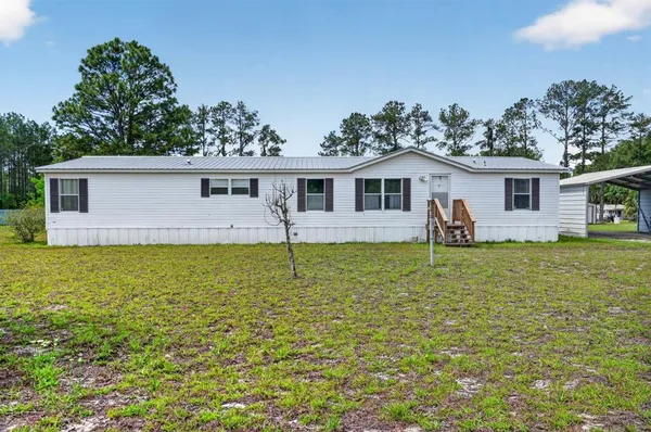 a front view of house with yard and outdoor seating