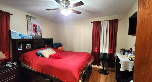 a bedroom with a bed dresser and a large mirror