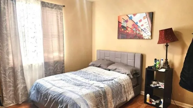 a bedroom with a bed and a painting on the wall