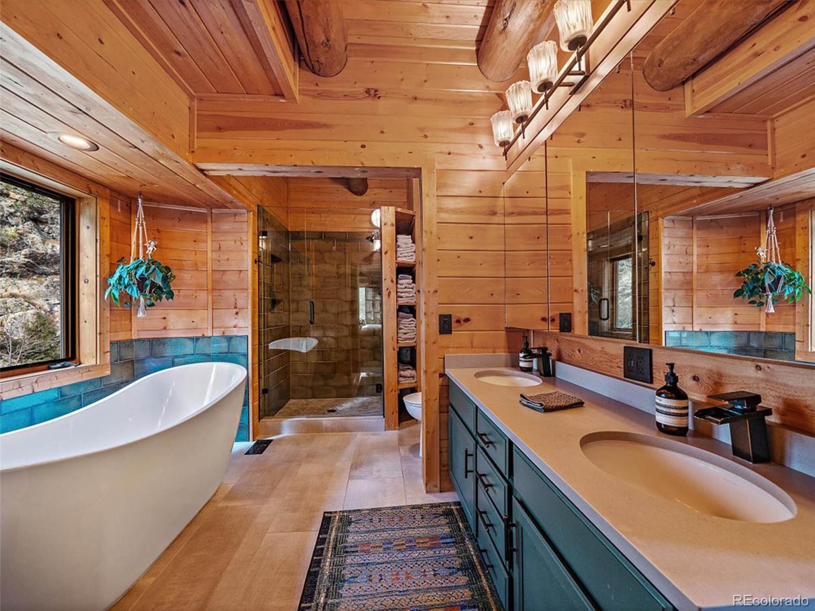 3602 Riverside Drive Lyons, CO 80540 - Photo 15 of 40 a bathroom with a tub a sink a mirror and a shower