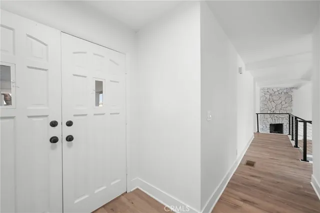 a view of a hallway with wooden floor and entryway