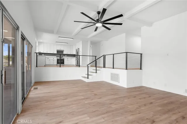 a view of a kitchen with wooden floor and a ceiling fan