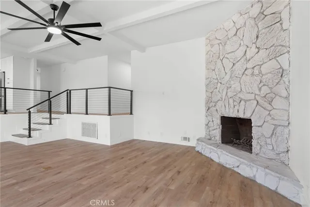 a living room with wooden floor and a fireplace