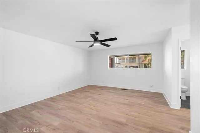 an empty room with a ceiling fan and window