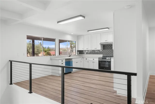 a kitchen with stainless steel appliances cabinets and a window