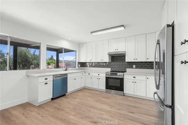 a kitchen with granite countertop white cabinets and white appliances