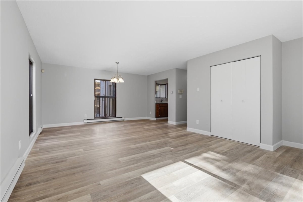 800 Bearses Way, Unit 2SB Barnstable, MA 02601 - Photo 11 of 40 a view of an empty room with wooden floor and a window