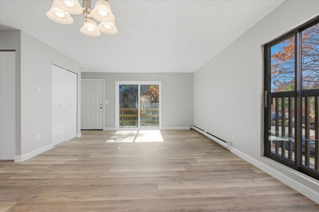 800 Bearses Way, Unit 2SB Barnstable, MA 02601 - Photo 12 of 40 a view of an empty room with wooden floor and a window